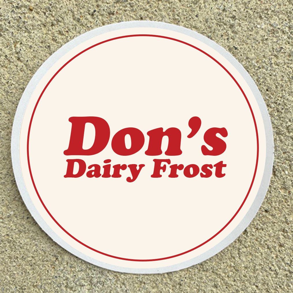 Round coaster with 'Don's Dairy Frost' text on a beige surface