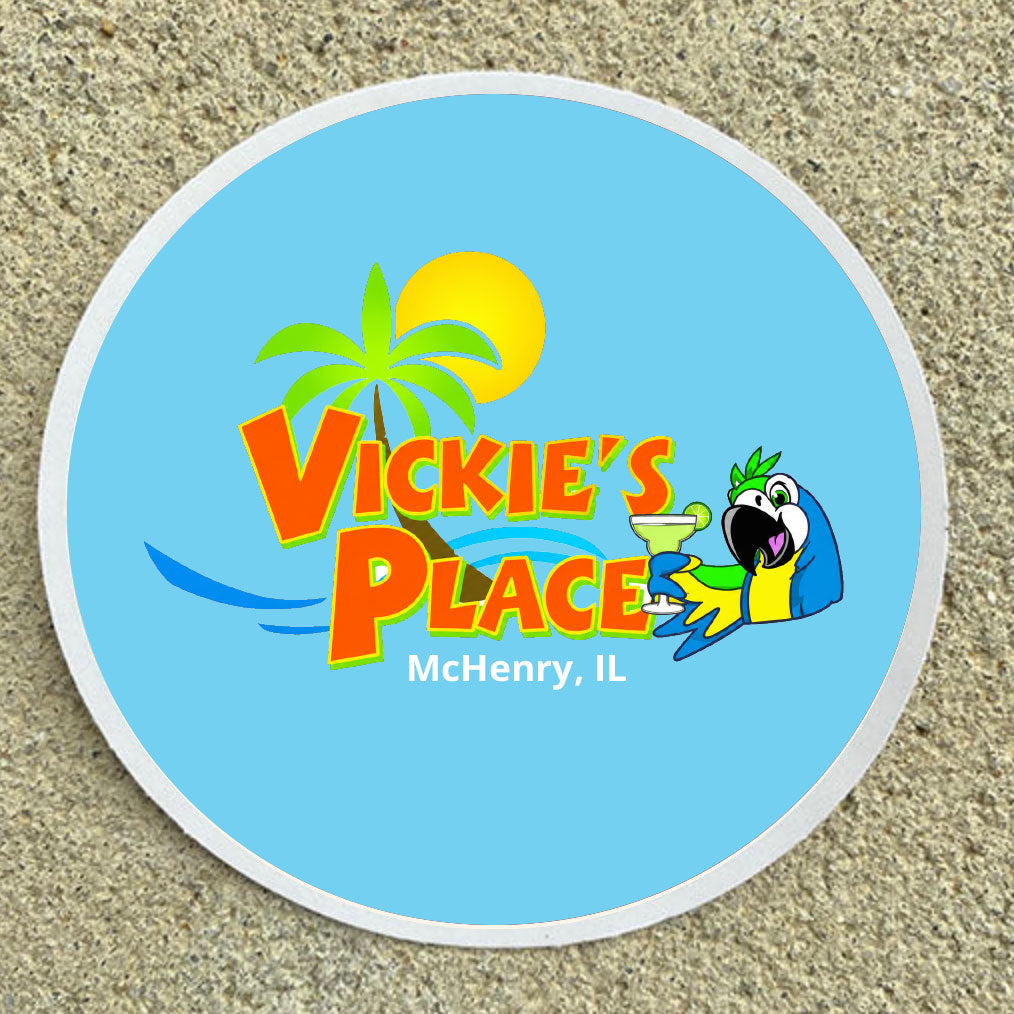Round blue sticker with 'Vickie's Place' logo featuring a parrot and palm tree on sand.